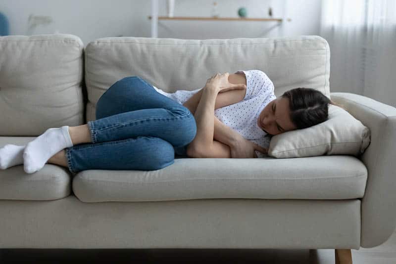 depressed young woman lying on the couch at home