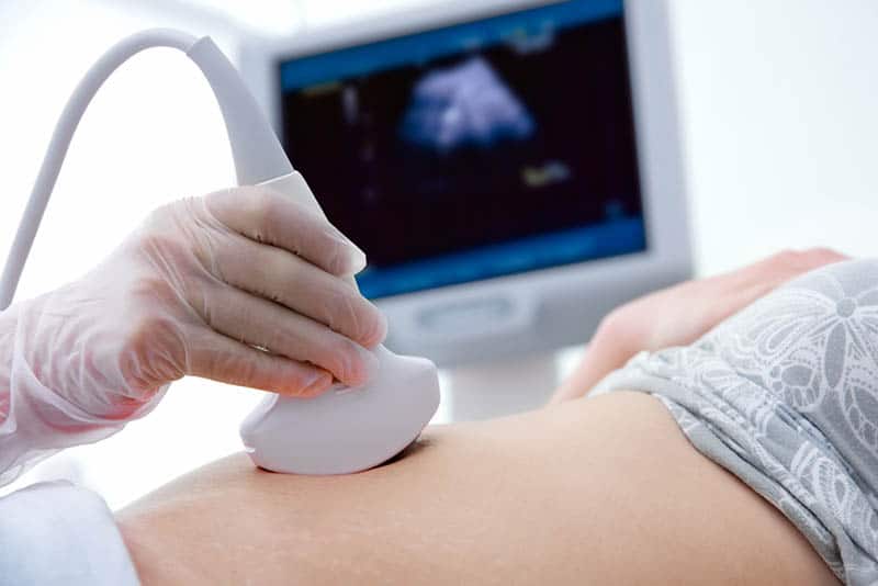 doctor doing an ultrasound examination to a pregnant woman in hospital