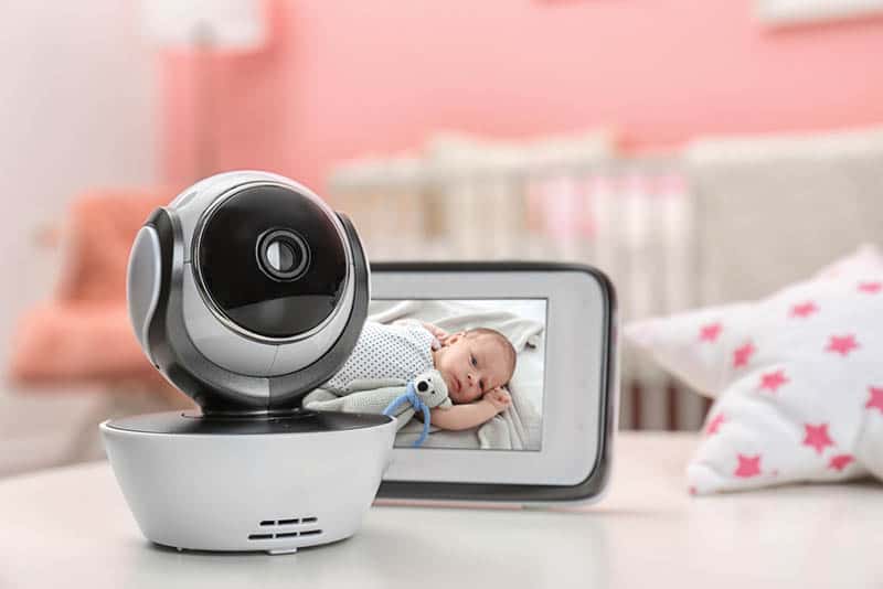 modern security camera with monitor and baby image on it on the white table in baby room