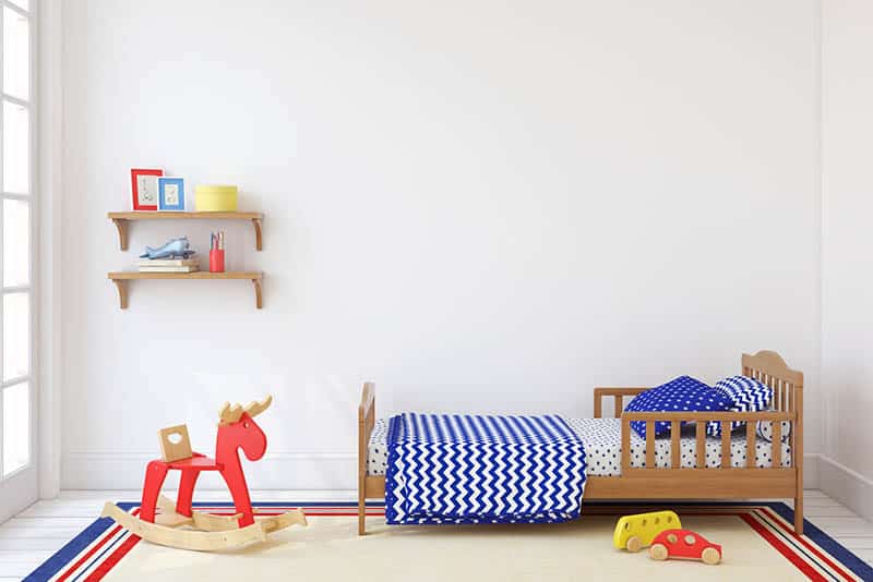 toddler bed with children's items and toys in the room