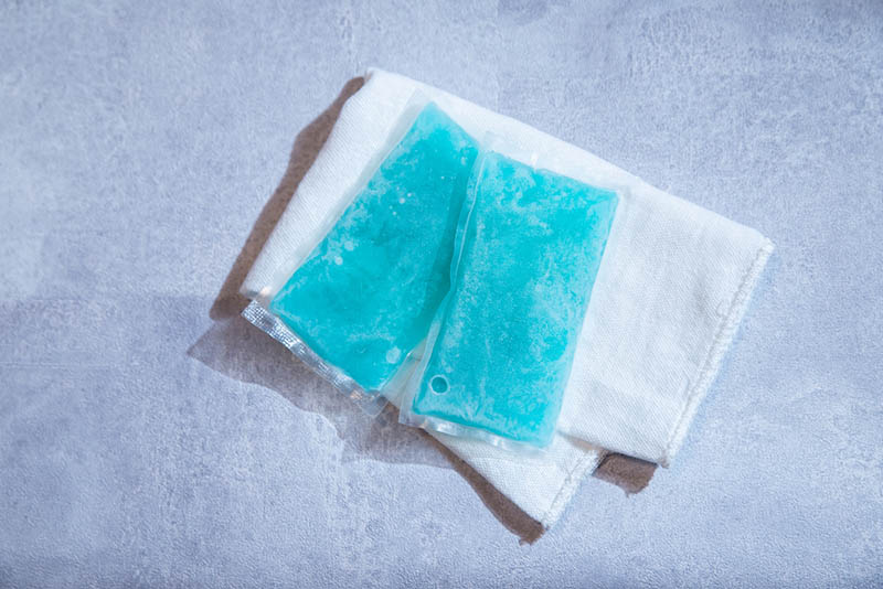 two frozen ice packs with white cloth on the grey desk