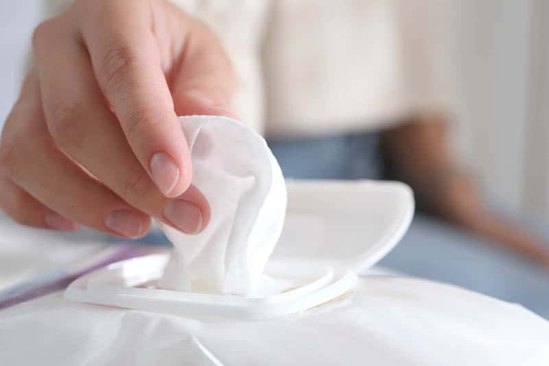 young woman pulling out a baby wipe out of white pack
