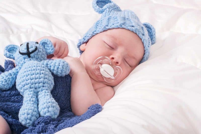 baby sleeping with a pacifier in his mouth