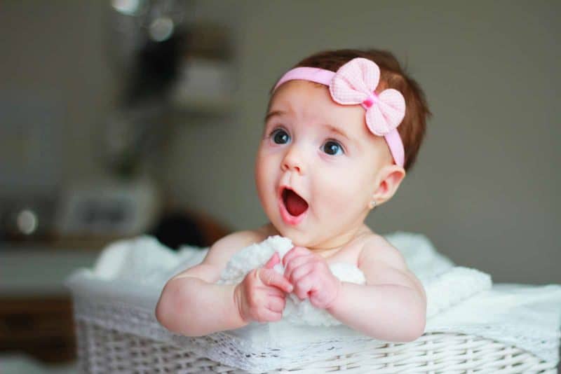 baby girl wearing a bow with a surprised facial expression