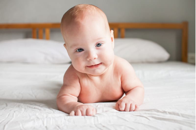Cute infant baby on a white bed