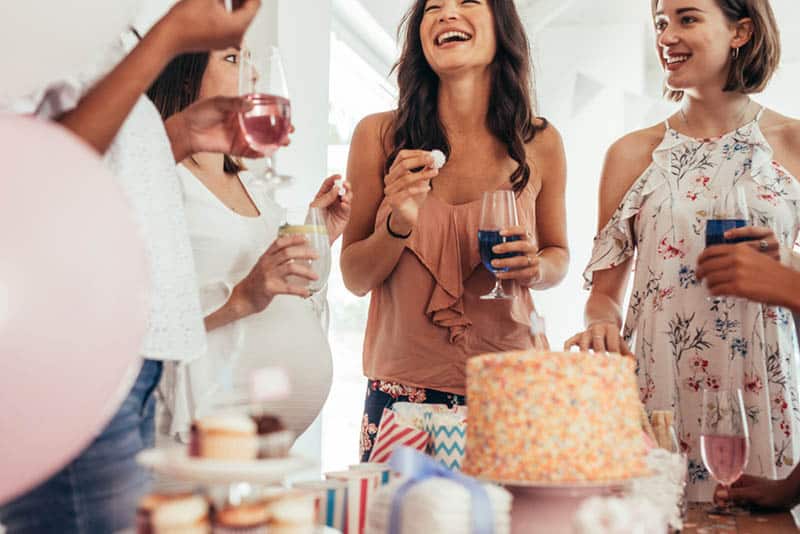Group of women at a baby shower enjoying food and drink