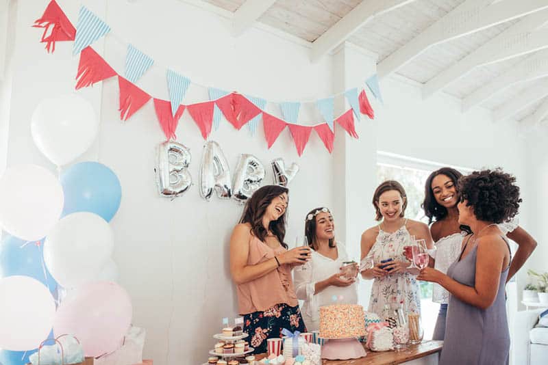 Pregnant woman celebrating baby shower with female friends at home
