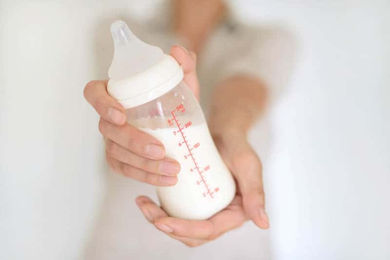Woman hand holding a baby bottle of breast milk