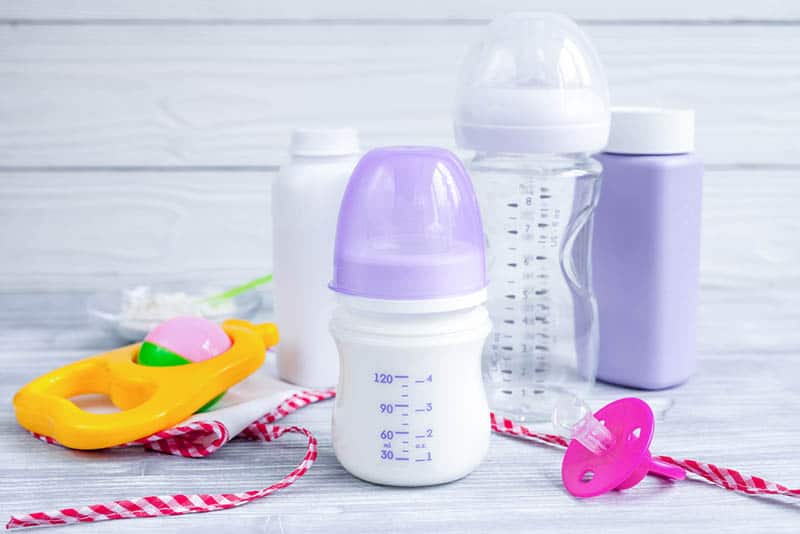 baby milk bottle with pacifier and baby items on the table