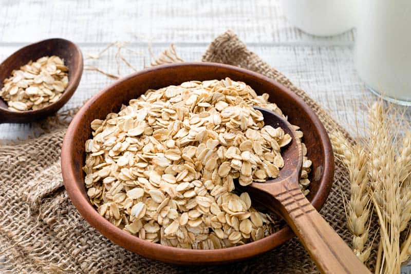 bowl full of oats with wooden spoon on the table
