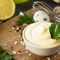 bowl of mayonnaise with ingredients on the cutting board