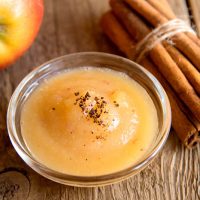 fresh applesauce with apple and cinnamon on wooden table