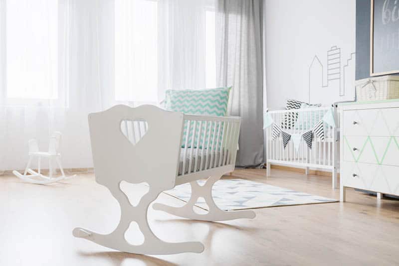 decorative white baby cradle with pillow in the baby room