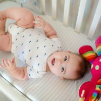 baby lying in a bassinet and smiling