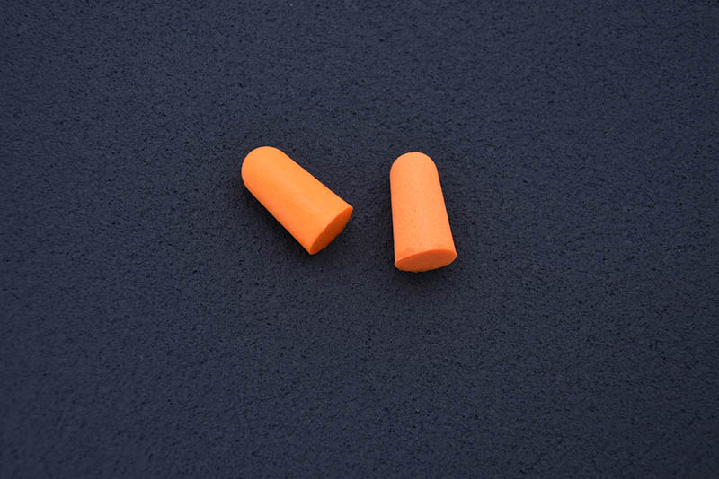 orange earplugs on dark table