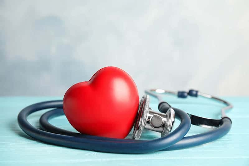 stethoscope and red heart on blue wooden table