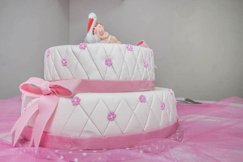 sweet pink cake for baby girls on the pink cloth on the table