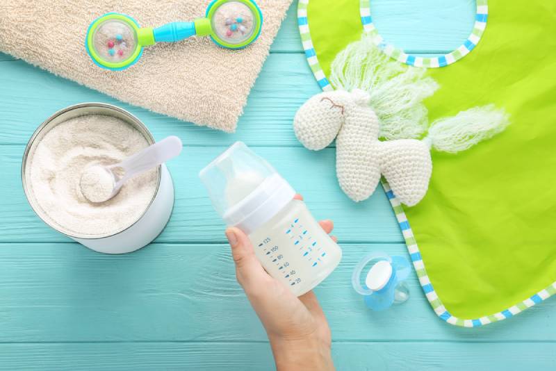 woman holding bottle with prepared baby formula