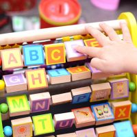 kid playing with educational toy with letters