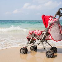 red baby beach stroller by the sea