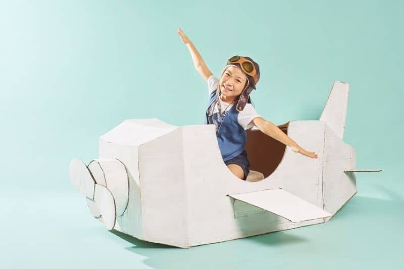 little girl pretending to fly an airplane