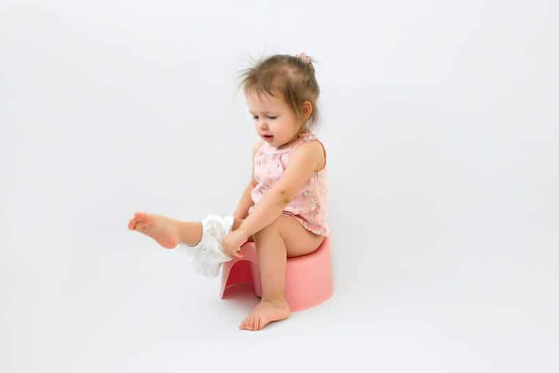 adorable little girl sitting on a potty with panties on leg
