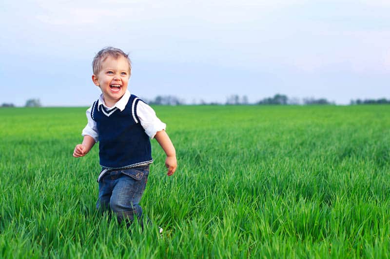 cute smiling boy running in the field