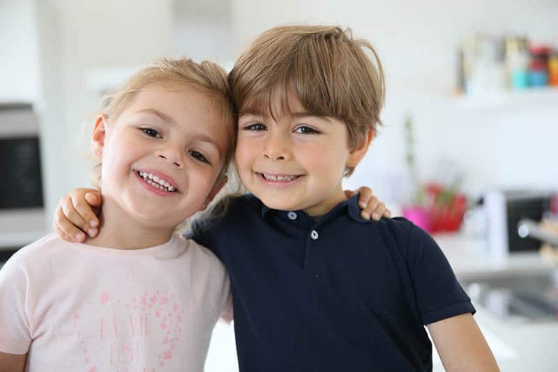 cute smiling siblings hugging at home