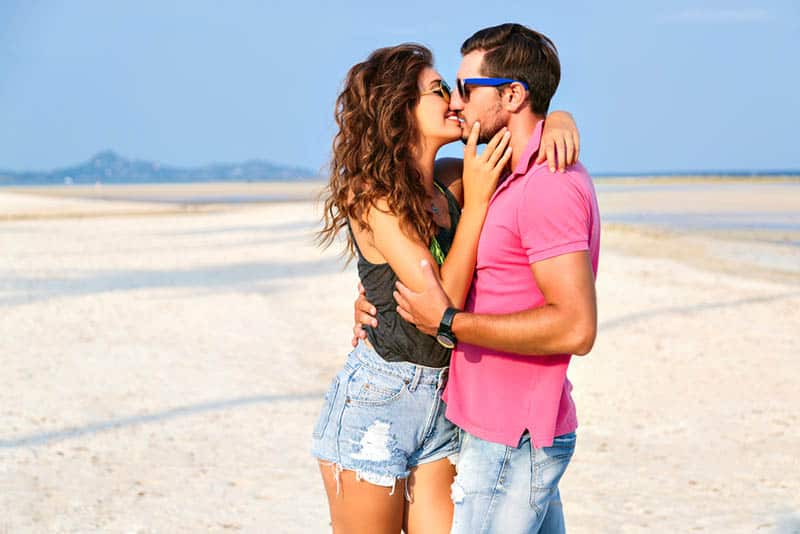 happy young couple kissing on the beach