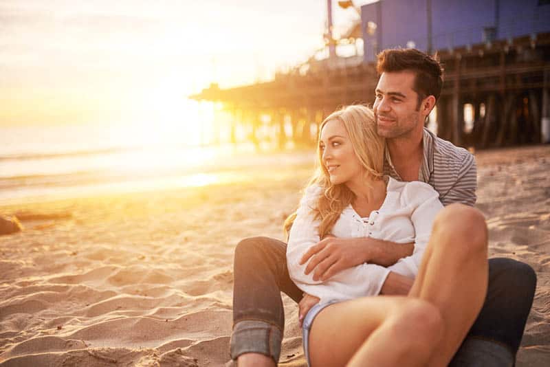 romantic couple enjoying sunset on the beach