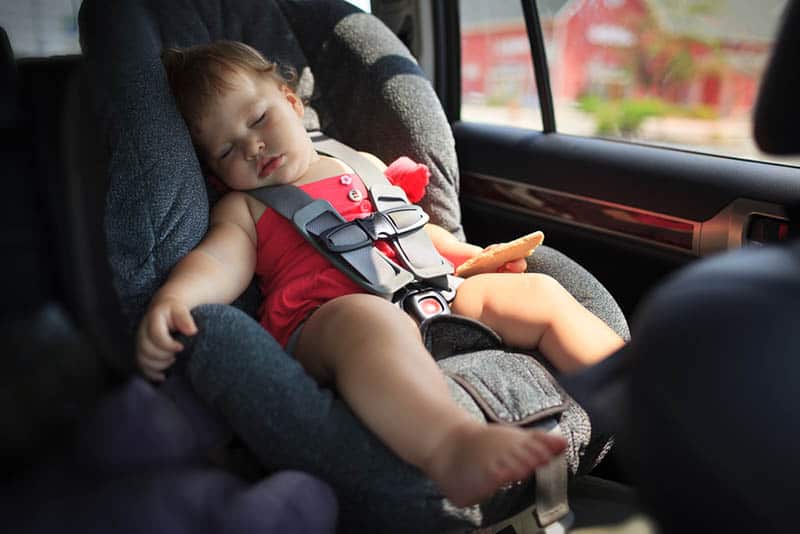 sweet baby girl sleeping in a car seat