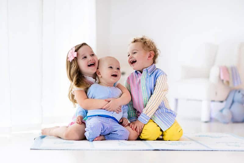 sweet siblings laughing and hugging on the floor