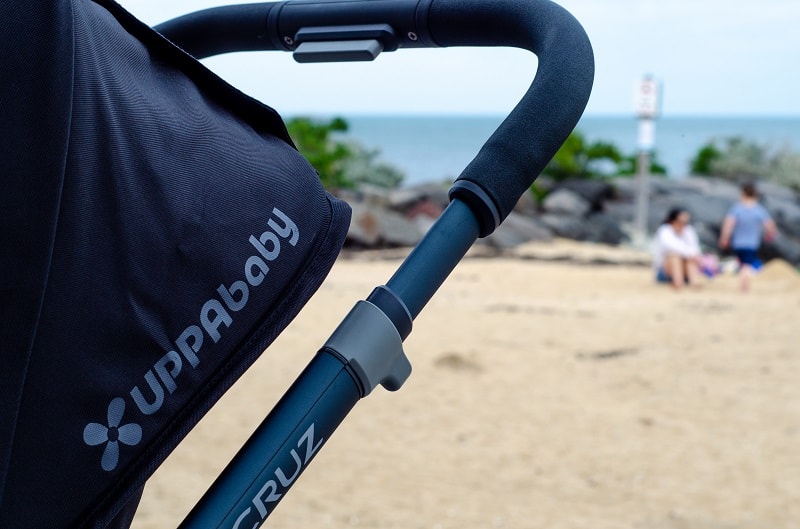 black uppababy stroller on the beach