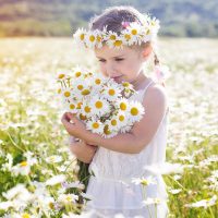 cute little girl with flowers in the field