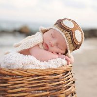 adorable baby boy sleeping in a wooden bassinet outside