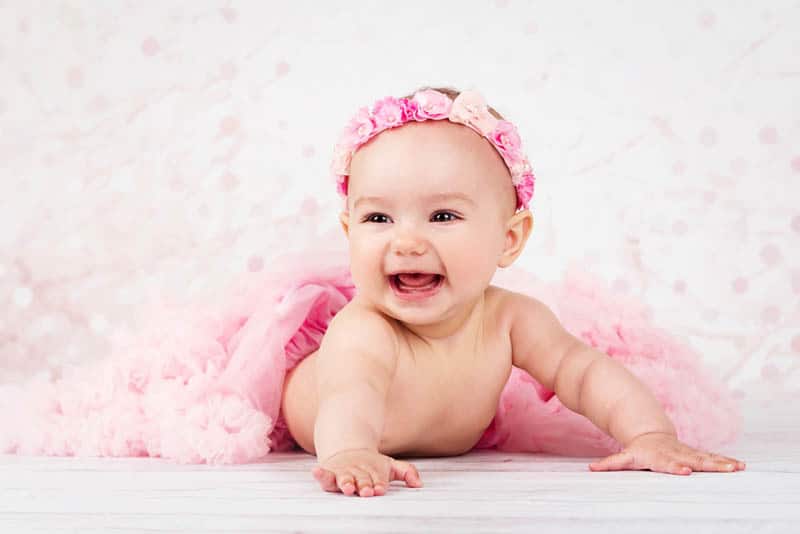 Adorable little baby girl crawling on the floor wearing tutu skirt