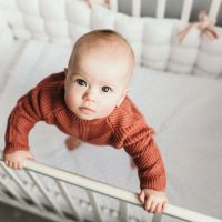 Little baby girl standing in her crib