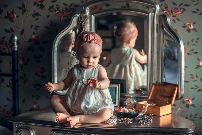 adorable baby girl playing with jewelry