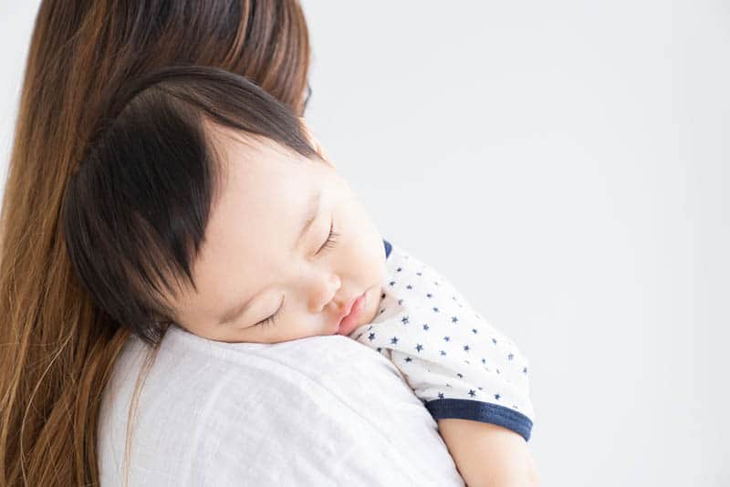 baby boy sleeping on mother's shoulder