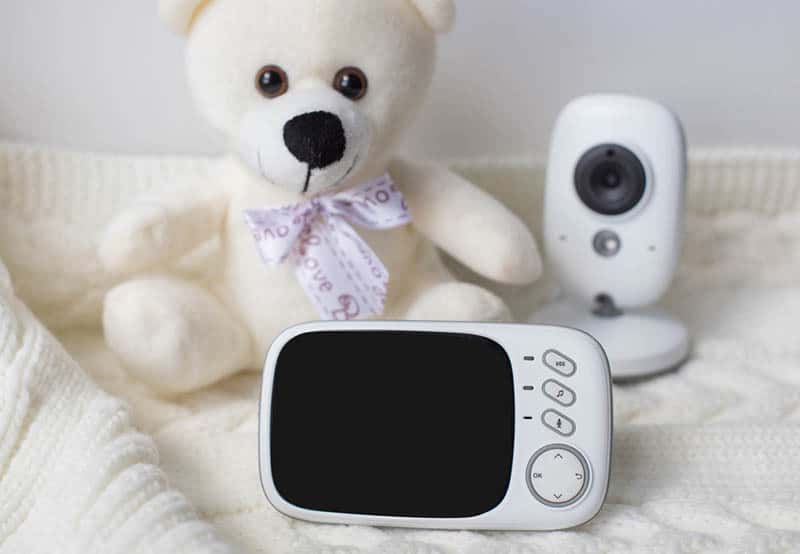 baby monitor and camera with teddy bear on blanket