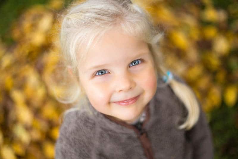 beautiful little girl with blond hair and blond eyes looking up