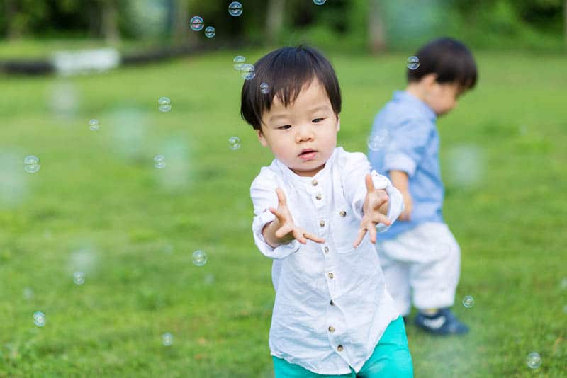cute little boys playing with bubbles outdoor