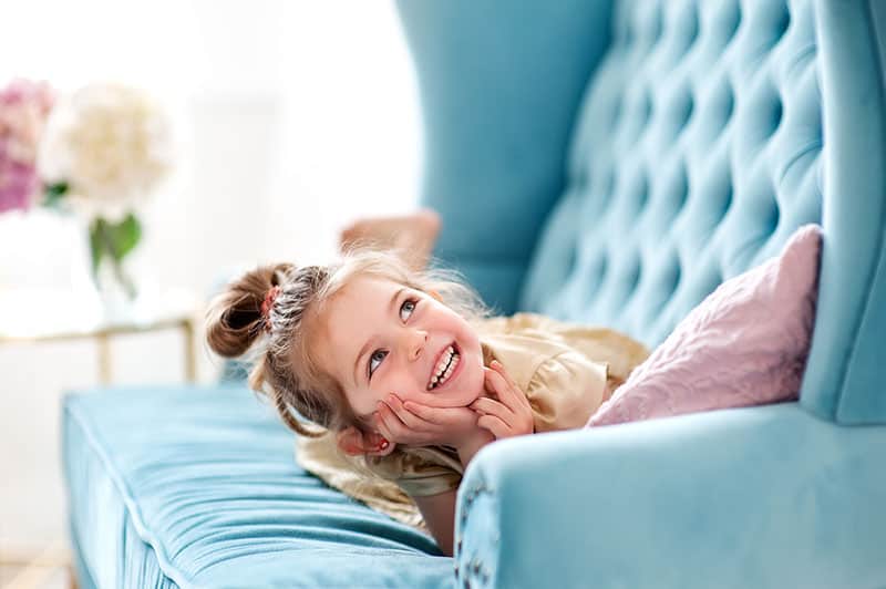 cute little girl smiling on sofa