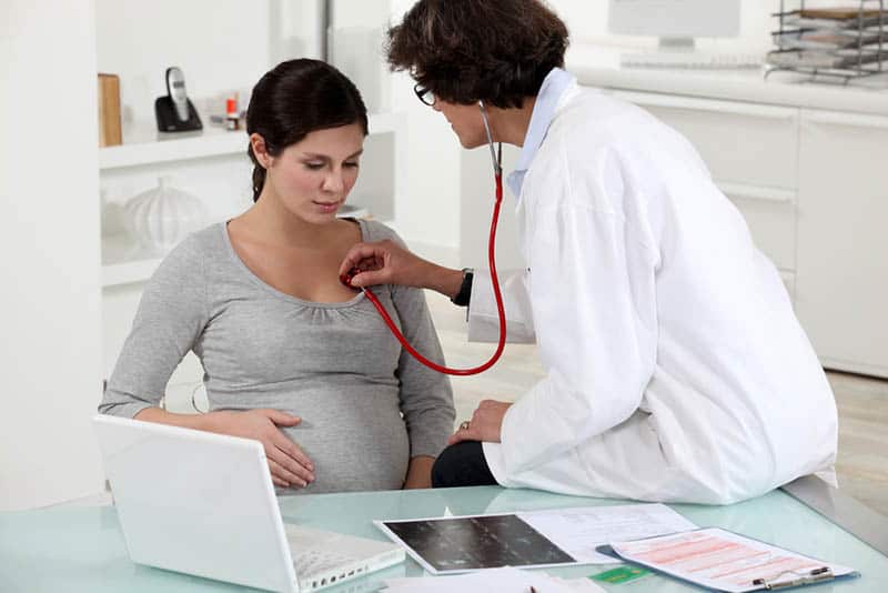 doctor examine pregnant woman heart beat
