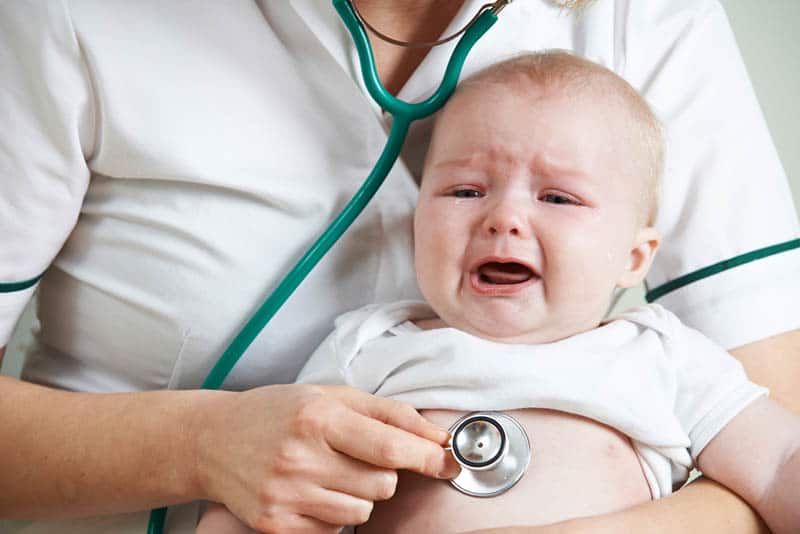 doctor listening crying baby chest with stethoscope