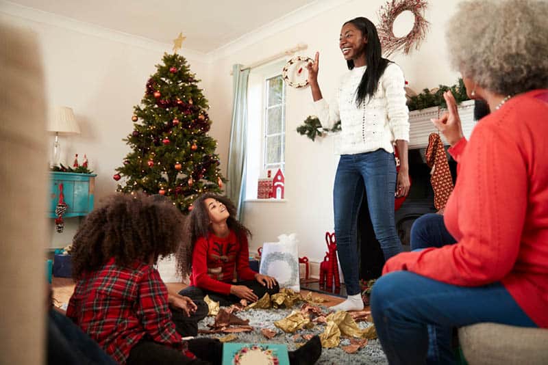 family playing charades at home on christmas