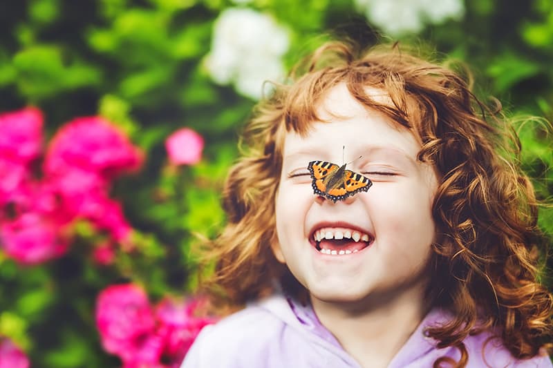 little red hair girl with butterfly on her nose smiling