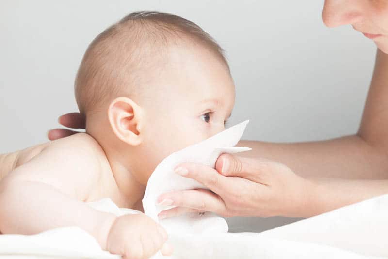 mother cleaning baby nose with handkerchief