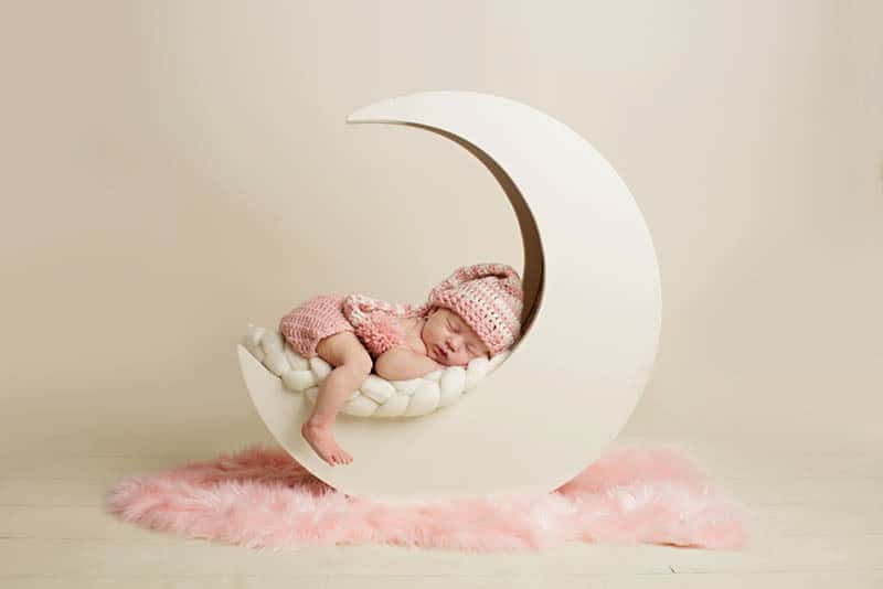 newborn baby girl sleeping while photoshooting in studio