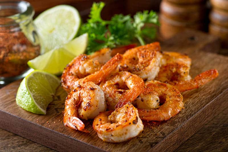 Delicious sauteed shrimp with cajun and lime on a cutting board